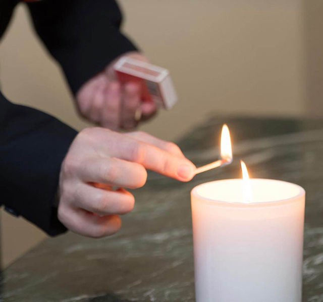 funeral director lighting a candle